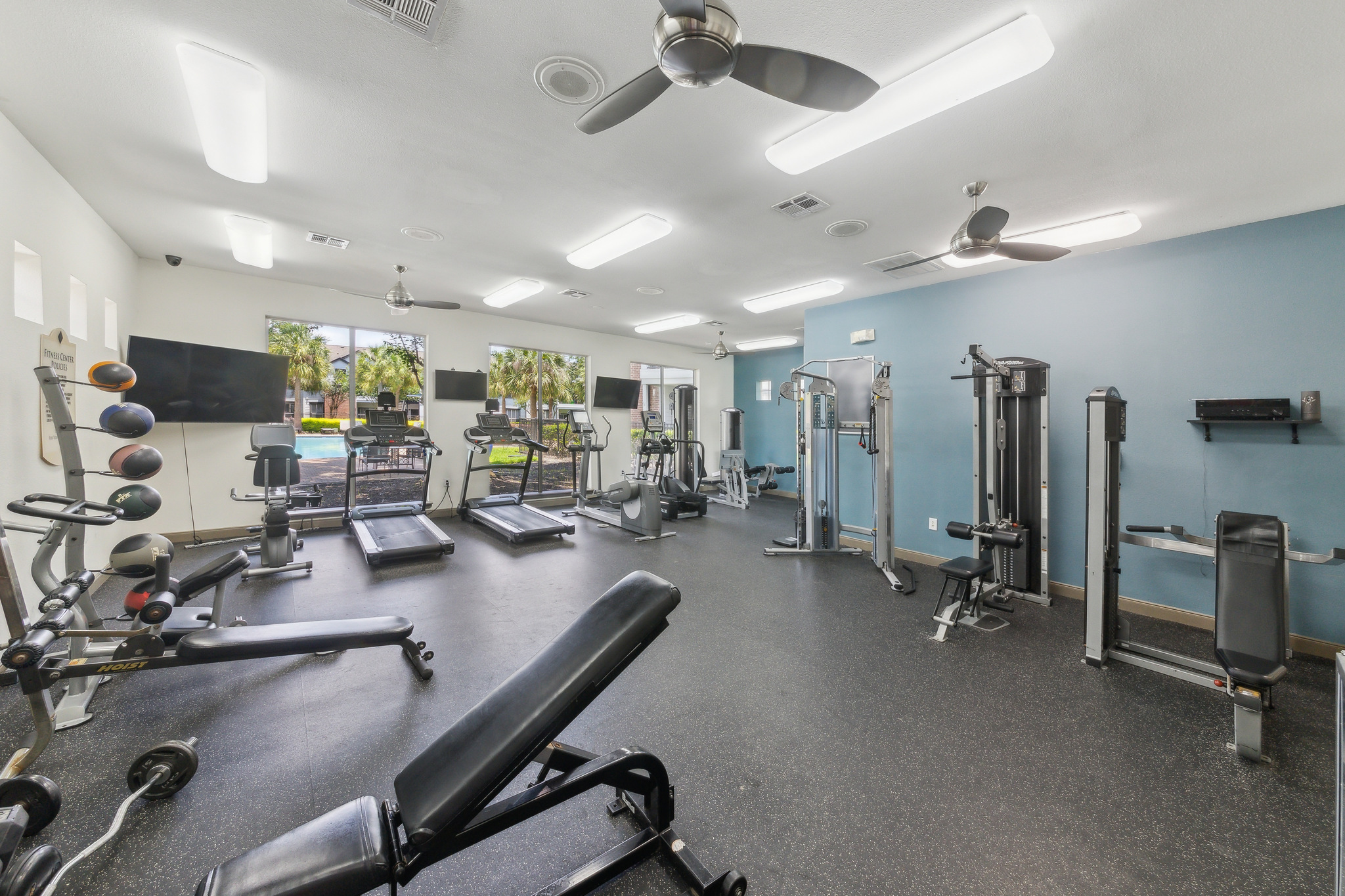 a gym room with exercise equipment and ceiling fans at The  Boulevard at Deer Park