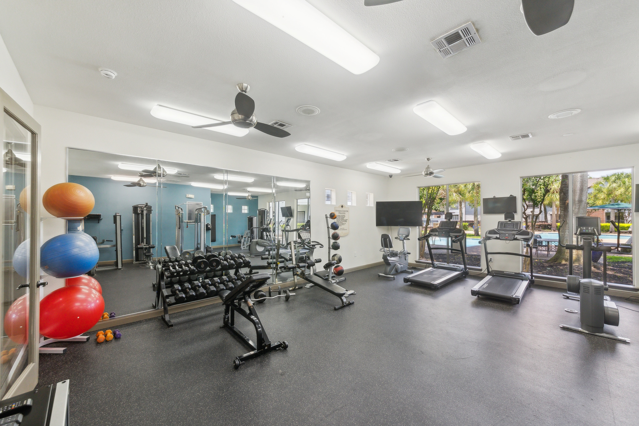a gym room with exercise equipment and a television at The  Boulevard at Deer Park